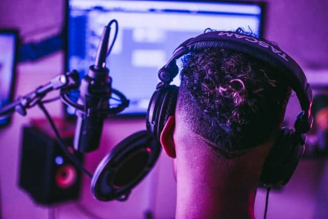 man in music studio with headphones on listening to exclusive beats